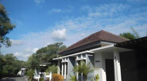 a small white house with a roof at The Luxio Hotel in Sorong