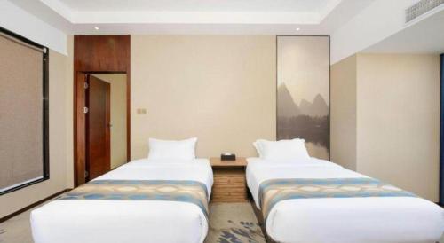 two beds in a hotel room with at Guilin Manhatton Hotel Tianjie in Guilin