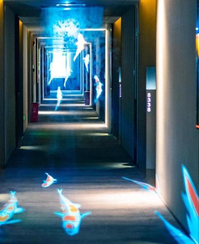 a hallway with cats running down a hallway with blue lights at Yuan Culture Hotel Shenzhen World Shajing in Shenzhen
