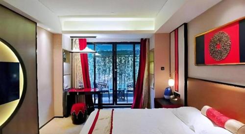 a bedroom with a bed and a view of a balcony at Yuan Culture Hotel Shenzhen World Shajing in Shenzhen