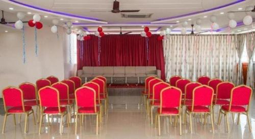 a room with a bunch of red chairs in a room at Hotel Gajur Palace in Itahari