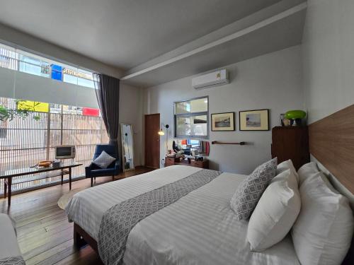 a bedroom with a bed and a large window at haus50s hometel in Hat Yai