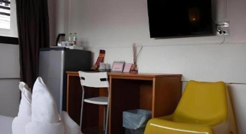 a room with a desk and a yellow chair at Iroom Hotel in Surat Thani