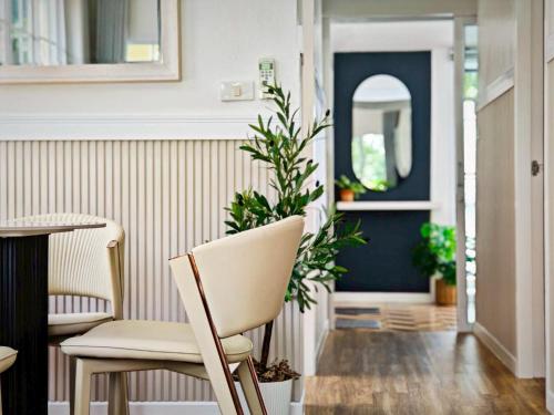 a dining room with a chair and a table at Canary Pool Villa Bangsaen in Ban Hua Khao Sammuk