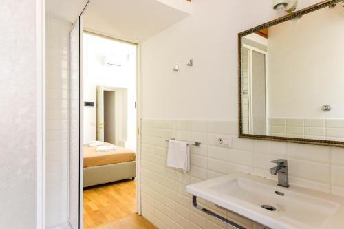 La salle de bains blanche est pourvue d'un lavabo et d'un miroir. dans l'établissement CS Cosy Termini Studio, à Rome