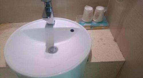 a bathroom with a white sink and two toilets at City Comfort Inn Foshan Shunde Daliang Qinghui Garden Xinsong in Shunde