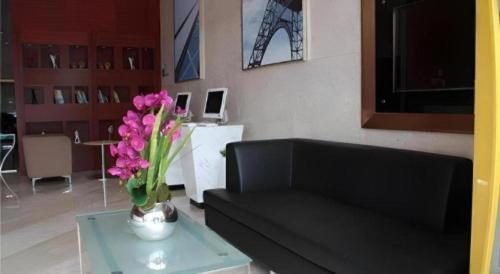 a living room with a vase of flowers on a table at City Comfort Inn Foshan Shunde Daliang Qinghui Garden Xinsong in Shunde