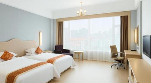 a hotel room with two beds and a large window at Putian Haiyuan International Hotel in Putian