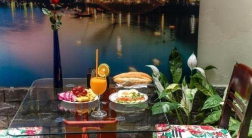 a table with two plates of food and a drink at Kim's Villa Hoi An in Hoi An