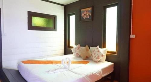 a bedroom with a bed with white sheets and pillows at Wanghin Bungalow in Surat Thani