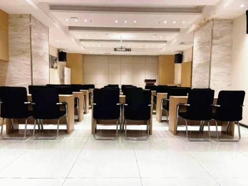 a conference room with black chairs and tables in it at City Comfort Inn Wuhan Wansongyuan Wangjiadun East Metro in Wuhan