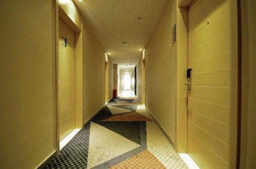 a hallway with a tile floor and a door at City Comfort Inn Wuhan Wansongyuan Wangjiadun East Metro in Wuhan