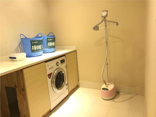 a laundry room with a washer and dryer at City Comfort Inn Wuhan Wansongyuan Wangjiadun East Metro in Wuhan