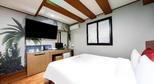 a bedroom with a bed and a flat screen tv at Chuncheon World Hotel in Chuncheon