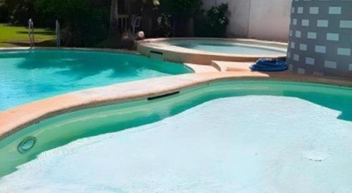 two large swimming pools with blue and green water at Hotel Camila 2 in Dipolog