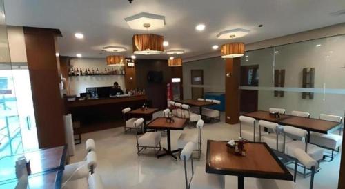 a restaurant with tables and chairs and a bar at Hotel Camila 2 in Dipolog