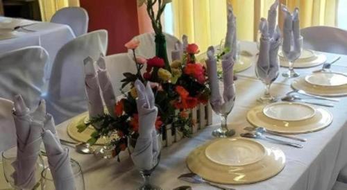 a table with a white table cloth with flowers and candles at Hotel Camila 2 in Dipolog