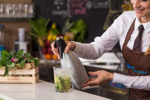 a woman pouring a drink into a glass at Hotel Acquadolce in Peschiera del Garda
