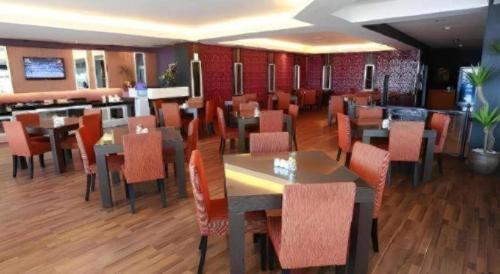 a dining room with tables and chairs in a restaurant at Hotel Formosa in Manado