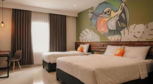 a hotel room with two beds and a painting on the wall at Hotel Formosa in Manado