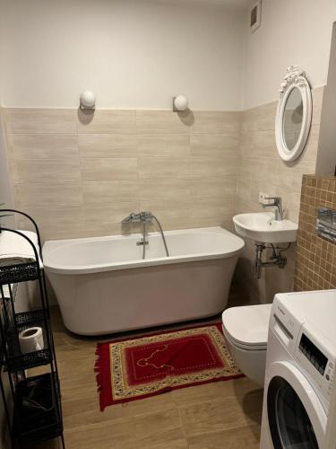 a bathroom with a tub and a sink and a toilet at Old town apartment in Vilnius