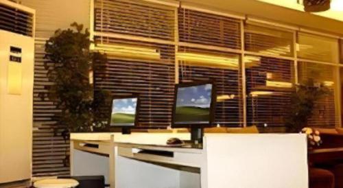 a computer desk with two monitors on top of it at Hotel Formosa in Manado