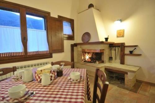 a dining room with a table and a fireplace at Azienda Agrituristica La Valle del Sambuco in Norcia