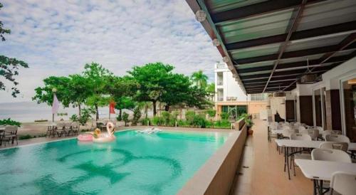 two people are in a swimming pool at a hotel at Subic Grand Harbour Hotel Subic Bay in Olongapo