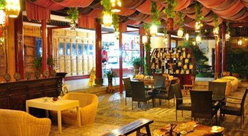 a restaurant with tables and chairs in a room at Lijiang Liwang Hotel in Lijiang