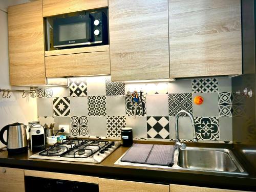 a kitchen with a stove top oven next to a sink at Casa Malù, Corso Italia Piombino AC in Piombino