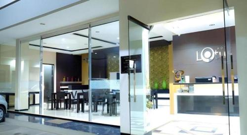 a dining room and kitchen with a glass wall at Lotus Hotel Subang in Bandung
