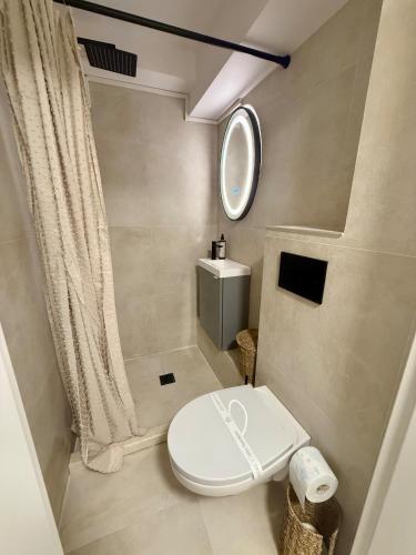 a bathroom with a white toilet and a mirror at Constanta Seaside Studio Demisol in Constanţa