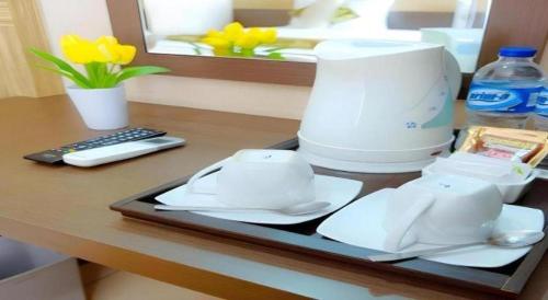 a counter with a coffee maker on a table at Lotus Hotel Subang in Bandung