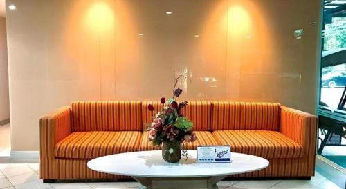 a orange couch sitting in a room with a table at Huern Che Ta One Hotel in Phrae
