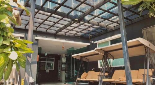 a building with a porch with chairs in front of it at Huern Che Ta One Hotel in Phrae