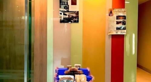 a room with a rainbow colored wall with a table at Huern Che Ta One Hotel in Phrae