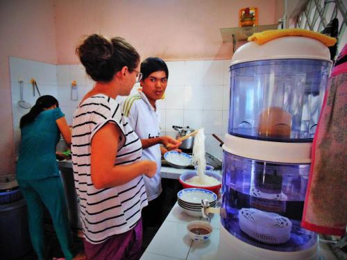 a group of people in a kitchen preparing food at Flower & Frog Homestay in Sa Ðéc