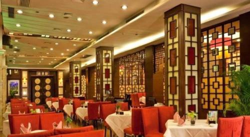 a restaurant with red chairs and tables in a room at Chinflux Mandarin Hotel in Dongguan