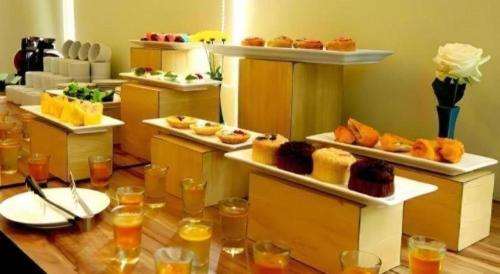 a buffet line with different types of pastries on shelves at Fitra Hotel Majalengka in Majalengka