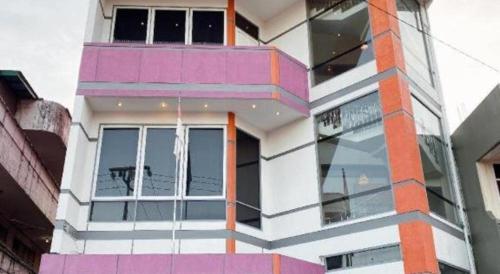 a pink and white building with a window at Hotel D' CaLia Tarakan in Tarakan