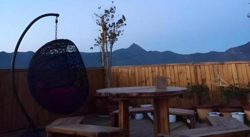 a patio with a table and benches and a fence at Lijiang Peach Hostel in Lijiang