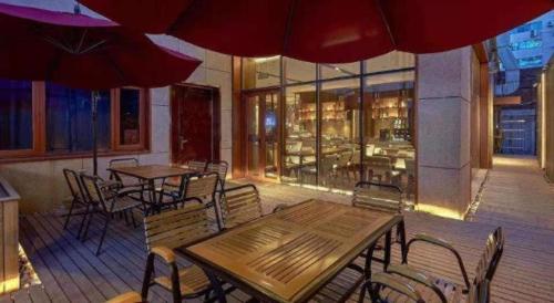 a restaurant with tables and chairs and umbrellas at NH Shijiazhuang Financial Center in Shijiazhuang