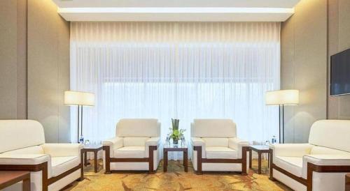 a room with two chairs and a table and a window at NH Shijiazhuang Financial Center in Shijiazhuang