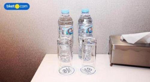 two bottles of water sitting on top of a table at Kenari Tower Hotel in Makassar