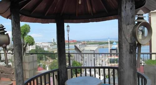 a gazebo with a table and an umbrella on a balcony at Kenari Tower Hotel in Makassar