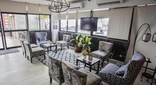 a room with chairs and a table and a tv at Kenari Tower Hotel in Makassar