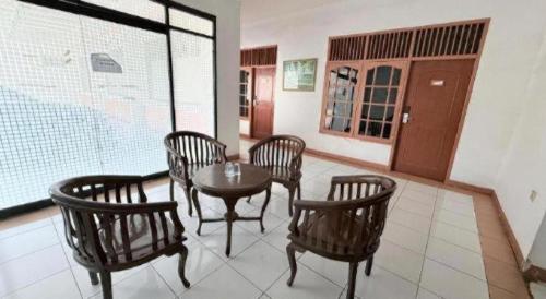 a room with a table and chairs and a window at Hotel Huswah Airport in Jakarta