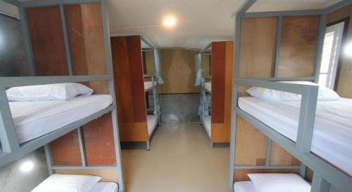 a room with three bunk beds in a room at Chomjan Hostel in Ko Phayam