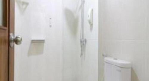 a door to a bathroom with a toilet and a phone at Hotel Huswah Airport in Jakarta