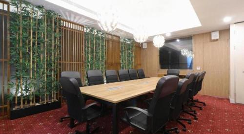 a conference room with a long table and chairs at Hotel Huswah Airport in Jakarta